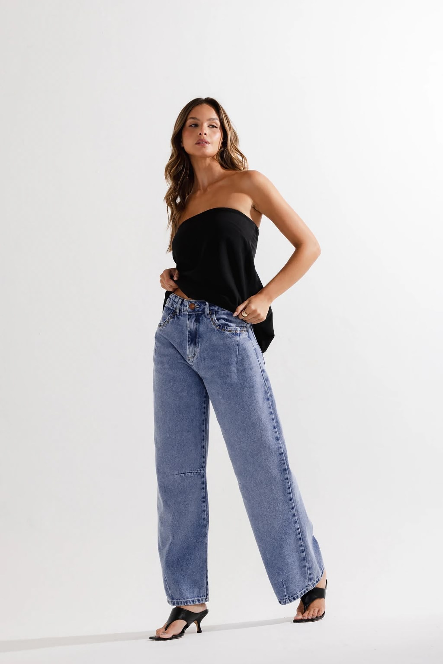 Modelo usando top preto e calça jeans wide leg