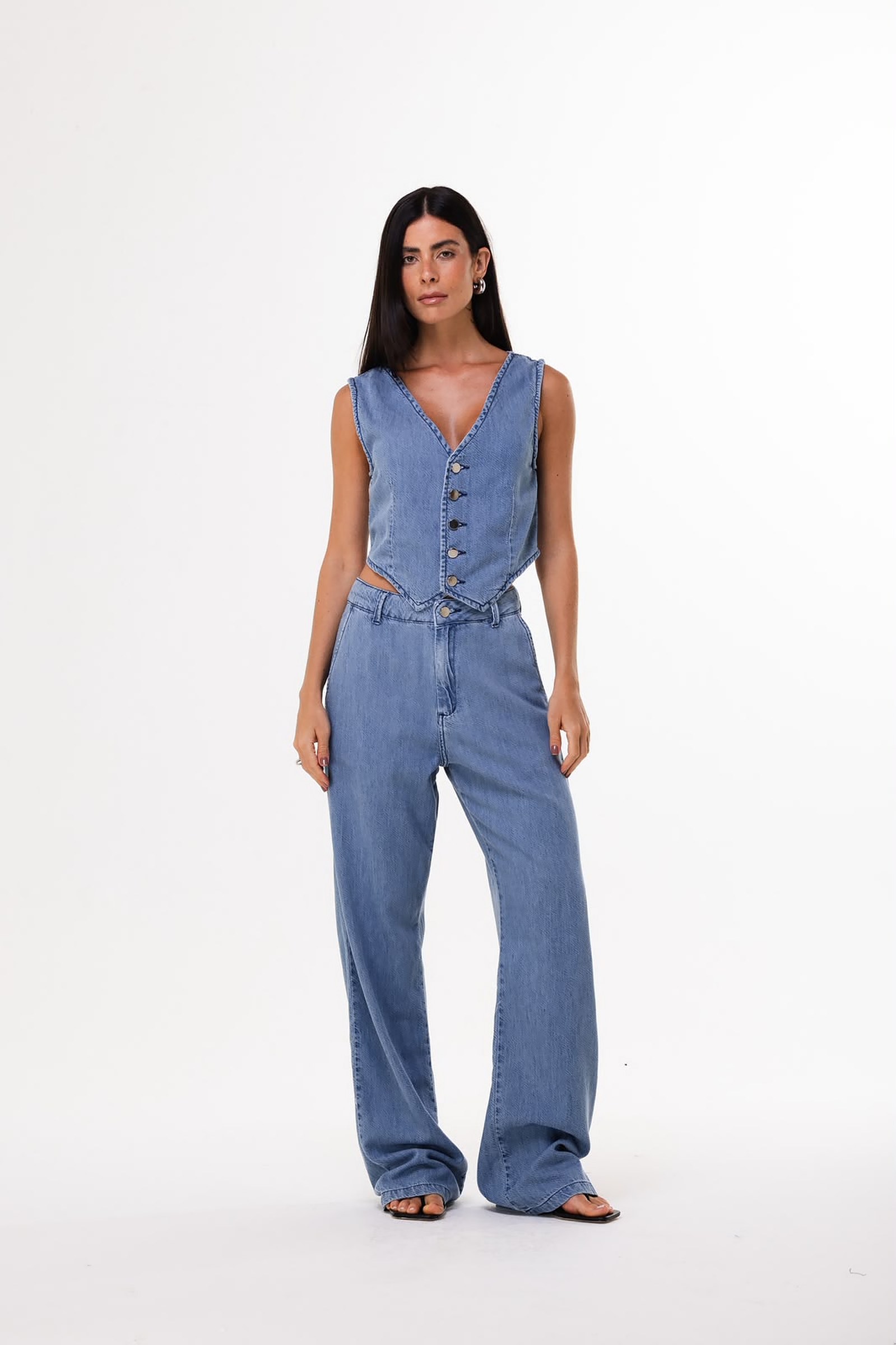 Modelo usando conjunto de colete e calça jeans claros